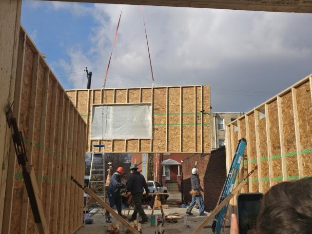 The highly efficient wall panels consist of (from inside to outside) 1/2-inch drywall; a 2-by-3 wiring and utility chase; 7/16-inch OSB; 9.5-inch lumber and OSB I joists set at 24 inches on center; joist bays filled with 9.5 inches of dense-packed cellulose; 7/16-inch coated OSB sheathing; rainscreen; fiber-cement panel siding.