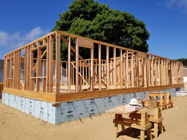 The home uses advanced framing techniques like 2-by-6, 24-inch on-center construction, minimal framing around windows, and insulated heaters to reduce lumber use and increase space for insulation in the walls.