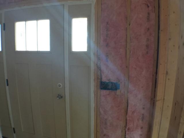 Open headers above doors and windows on non-load-bearing walls allow for rigid foam and fiberglass to fill these sometimes uninsulated spaces, while low-expanding spray foam fills gaps around the door frame to minimize drafts and heat loss.