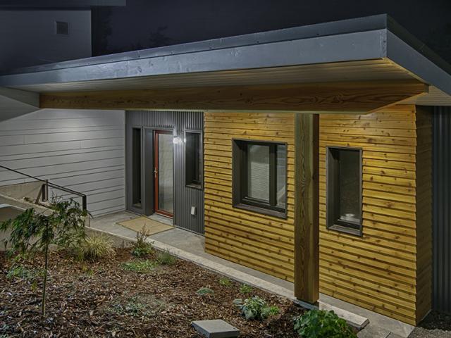 The exterior walls of this high-performance home are actually two stud-framed walls built side-by-side to form a thick wall cavity that was stuffed with fiberglass insulation and wrapped with an OSB sheathing that was glued at the edges and covered with a taped house wrap to provide a continuous water and air barrier behind the ¾-inch drainage plane material, which provides a ventilation gap under the fiber cement, metal, and fir siding.