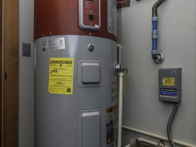 The 80-gallon heat pump water heater pulls heat from outside air drawn from the south side of the house and exhausts cooled air outside on the north side of the house to efficiently heat water without impacting interior room temperatures.