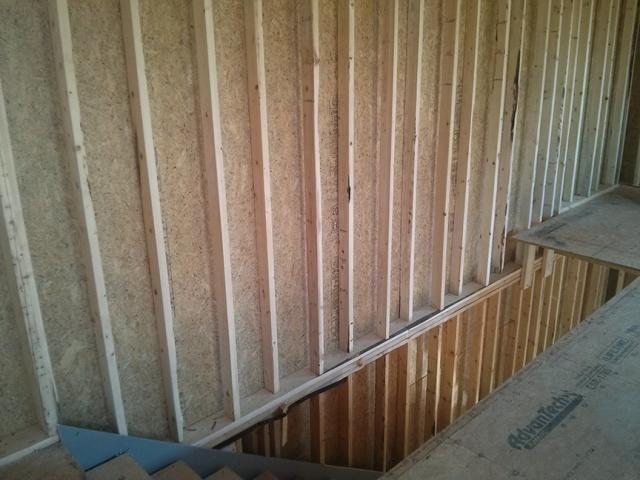 The builder staggers 2-by-4 studs on 2-by-6 top and bottom plates, which provides gaps to fill in insulation around the framing for a continuous blanket of insulation.