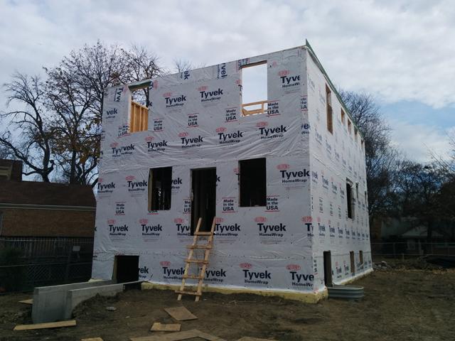 House wrap is carefully installed to provide a continuous air and water barrier around the home.