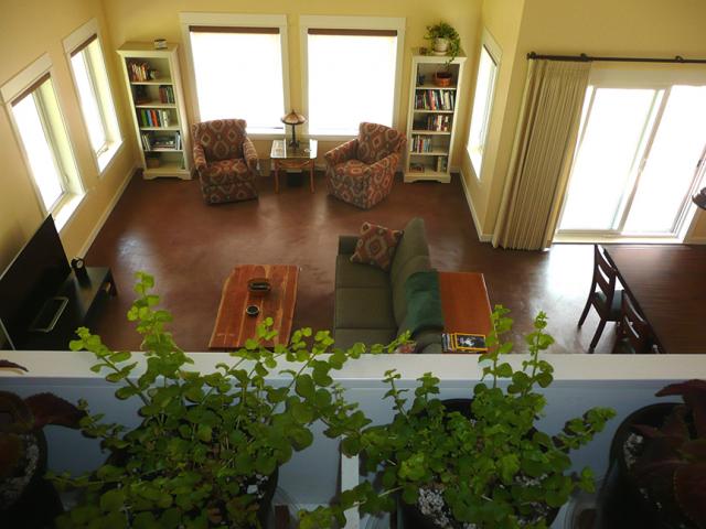 The large south-facing windows allow any available sunlight to warm up the stained concrete floor slab, providing passive heating to the home.