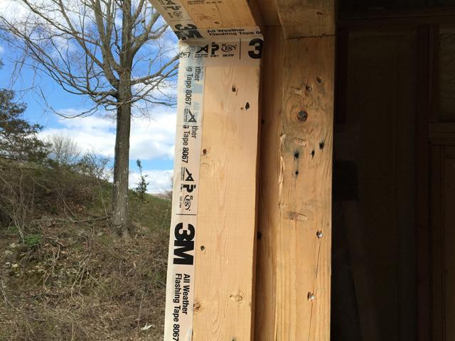 Air-sealing tape carefully seals the seams around the window framing.