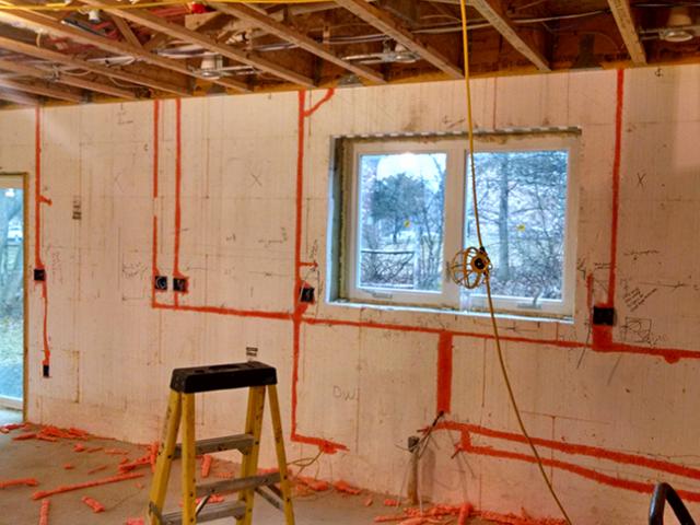 Wiring runs are covered with canned spray foam to maintain the continuous foam layer that covers the inside and outside of these ICF block walls.