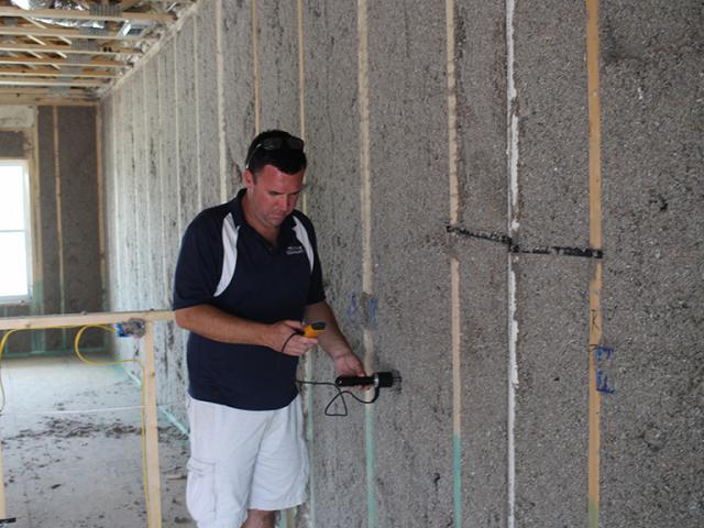 Moisture levels are checked in the blown cellulose insulation before enclosing the walls.