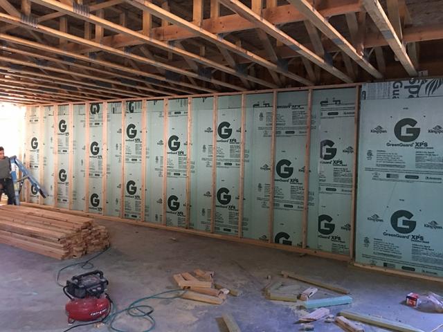 The poured concrete basement walls are insulated along the inside with 2.5 inches of R-12.5 polyiso rigid insulation.