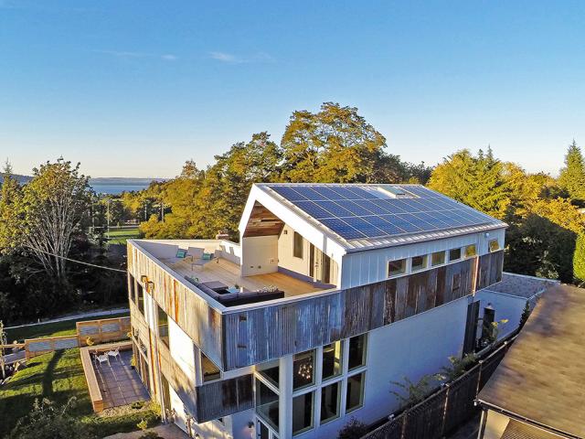 Energy-saving advanced framed walls use 2-by-8 framing filled with dense-packed cellulose (R-27). The OSB sheathing was covered with a fluid-applied asphalt weather-resistant barrier that was also used for window flashing. The wall assembly was finished with reclaimed metal and fiber cement siding.