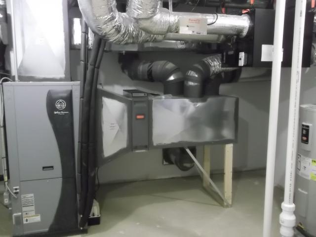 The ultra-efficient (COP 5.7) ground source heat pump uses a central air handler with modulating condensers and a variable-speed electrically commutated motor blower to distribute conditioned air. A balanced fresh air system uses an energy recovery ventilator connected to the air handler to continuously dilute contaminants.