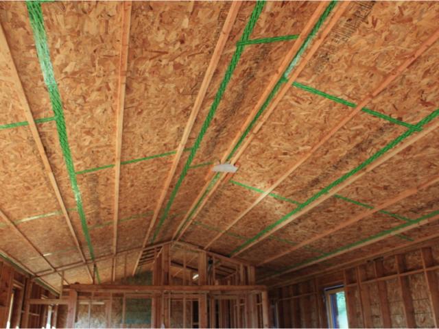 Under the attic rafters, an OSB air sealing layer was installed and all seams were sealed with an air sealing tape. A second drywall ceiling was installed below this providing a mechanical cavity in between the two layers for wiring or ducts while minimizing holes into the attic.