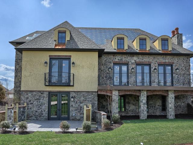 The structural insulated panel (SIP) thermal blanket wall system is clad with stucco and stone.