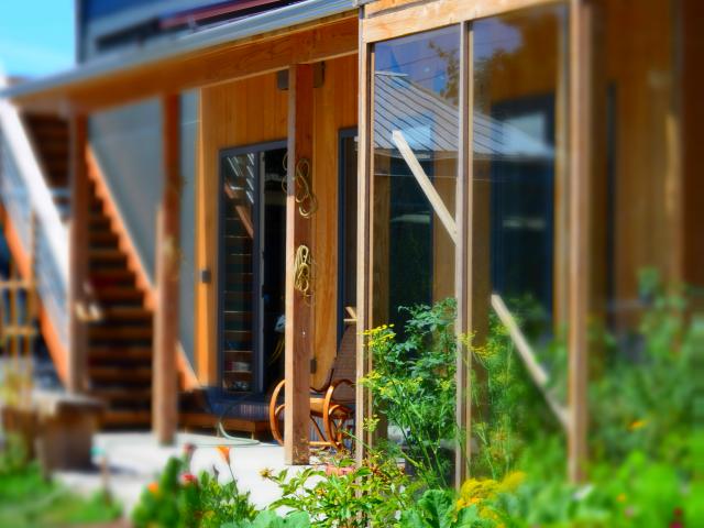 A greenhouse off the kitchen provides a thermal transition zone into the home, minimizing heat losses during the winter. The solar hot water heating panels are visible on the porch roof.