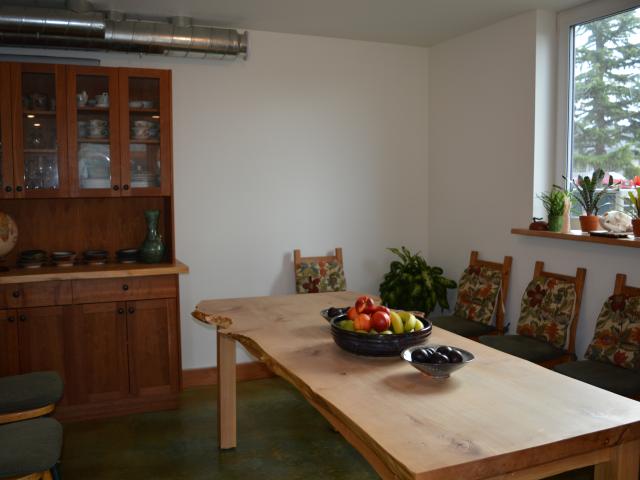 The pipes in the corner of the dining room are a supply air outlet for a heat recovery ventilator, which transfers heat between the fresh air being drawn in and the stale air being exhausted out to temper the incoming air.