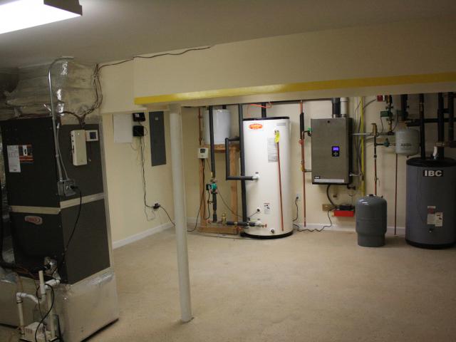 The mechanical room in the basement houses the water heating equipment, including the storage tank and wall-hung boiler as well as the air handler for the hydro coil and high-efficiency (16 SEER) air conditioner.