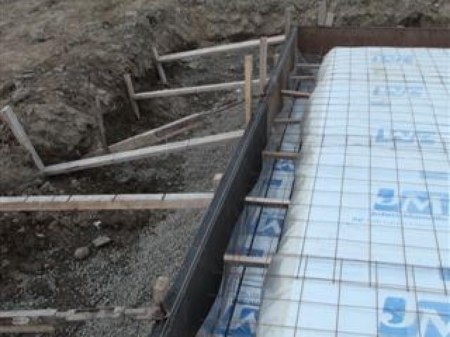 High-efficiency foundation insulation consists of 5.5 inches (R-36) of foil-faced rigid foam installed under the entire slab as well as 3 inches of rigid foam extending down the exterior of the foundation stem walls to 24 inches below grade and then out 41 inches to protect the foundation against frost damage.