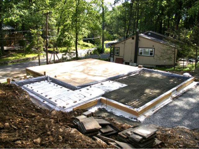 The enhanced comfort floor insulation includes 2.5 inches of closed-cell plus 5.5 inches of open-cell spray foam in the floor joists above the existing basement as well as the thick rigid foam layer under the newly poured slab foundation.