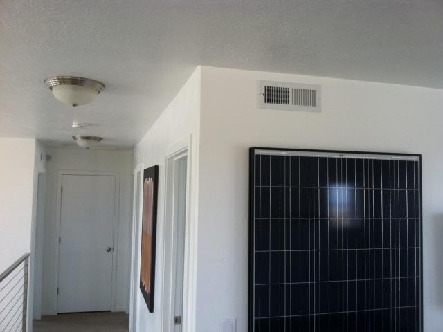 An ultra-efficient central air source heat pump with high-efficiency gas furnace backup provides heating and cooling delivered by an interior comfort delivery system with ducts installed in dropped ceiling soffits below the attic.