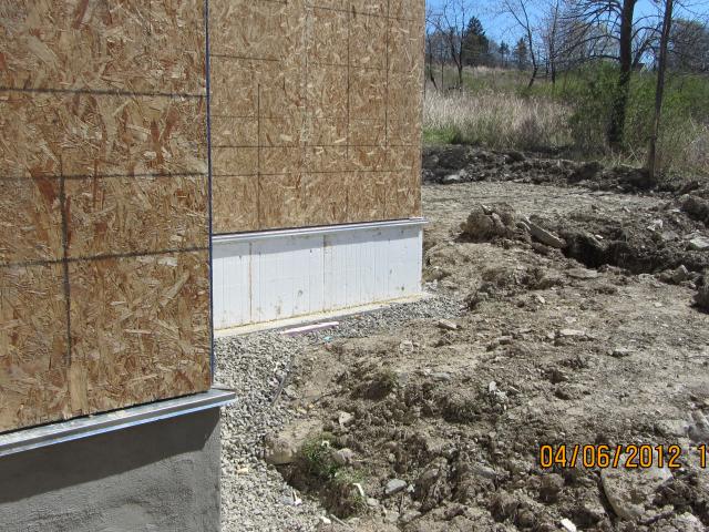 The high-efficiency foundation insulation uses R-15 rigid foam on the outside of the above-grade foundation walls.