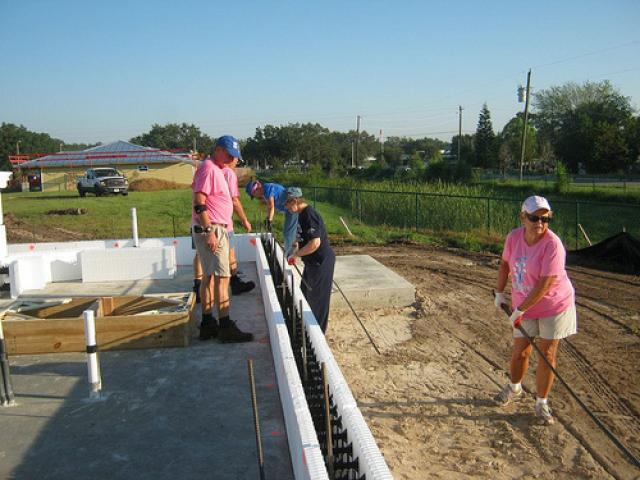 Volunteers are trained to construct thermal blanket walls using insulated concrete form (ICF) construction with hollow rigid foam insulation blocks that are filled with steel rebar and concrete.