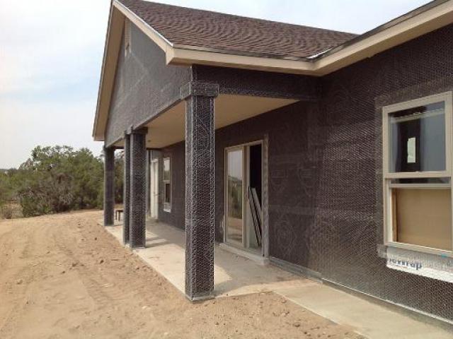 Wire mesh has been installed over the wall water barrier system in preparation for stucco cladding.