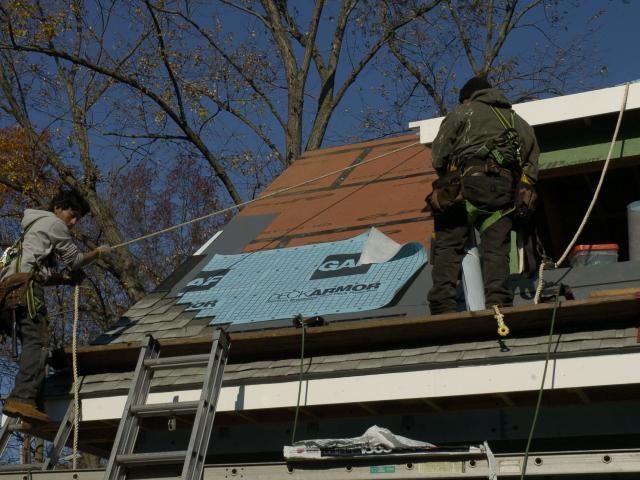 The multi-layered roof water barrier system includes roof sheathing joints taped and coated with waterproofing, an adhesive-backed roofing membrane applied at the overhangs, eaves, and valleys, and water-resistant, breathable, roof underlayment.