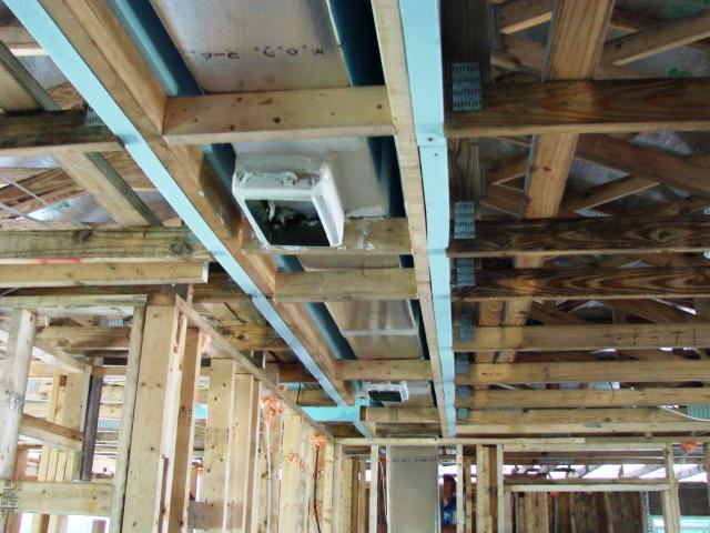 The main trunk line of the interior comfort delivery system runs within an insulated duct chase installed in a notch designed into the roof trusses. The trunk duct runs above the home's central hallway to supply conditioned air directly to most of the home's ceiling registers.