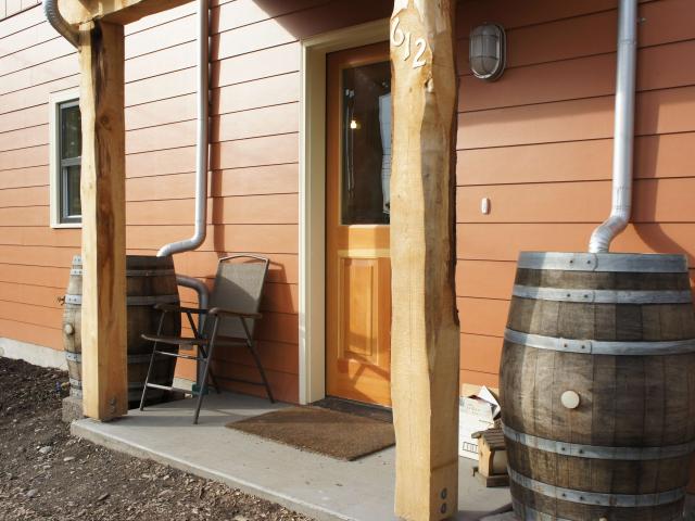 Rain barrels and proper site grading are among the details that will make this high-performance home durable as well as energy efficient.