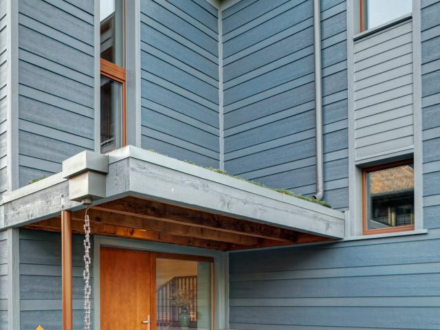 The green roof above the door of this high-performance home is one of many techniques the builder used to manage storm water runoff on the narrow site. Other techniques include underground retention wells, rain barrels, and a water-saving landscaping design.